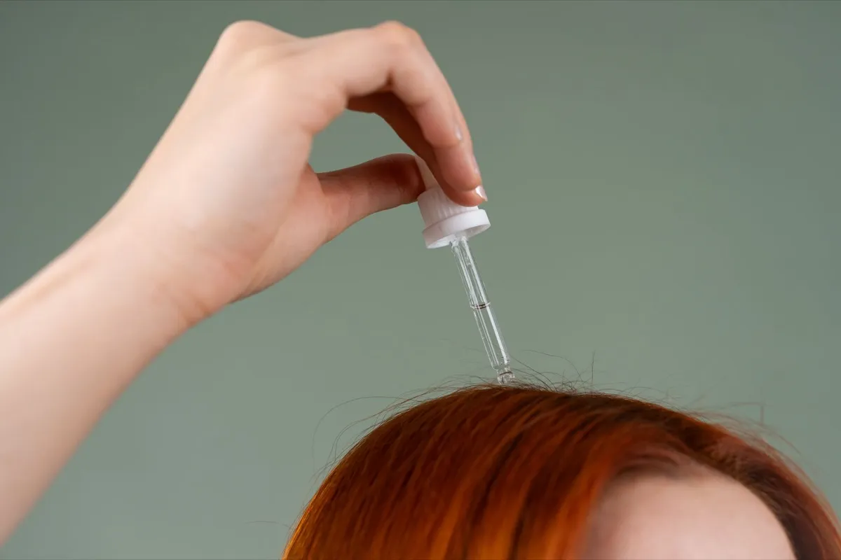 Serum being applied to the scalp with a dropper